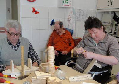 Bewohner des Altenheim Schweikershain basteln gemeinsam einen Zug aus Holz