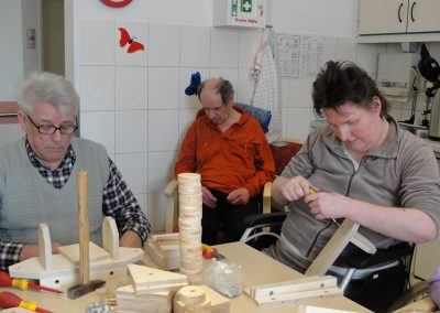 Bewohner des Altenheim Schweikershain basteln gemeinsam einen Zug aus Holz