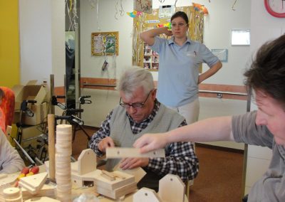 Bewohner des Altenheim Schweikershain basteln gemeinsam einen Zug aus Holz