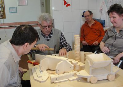 Bewohner des Altenheim Schweikershain basteln gemeinsam einen Zug aus Holz