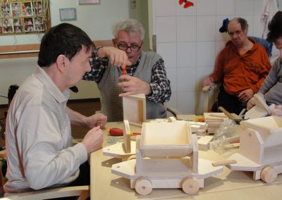 Bewohner des Altenheim Schweikershain basteln gemeinsam einen Zug aus Holz