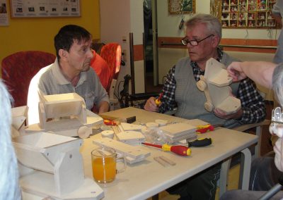 Bewohner des Altenheim Schweikershain basteln gemeinsam einen Zug aus Holz